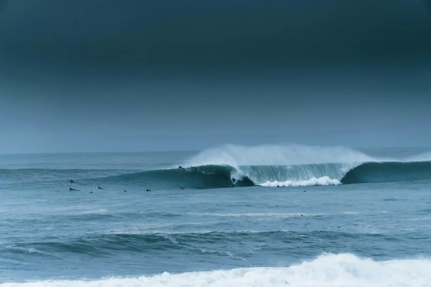 Une vague creuse à Hossegor, avec des surfeurs au large